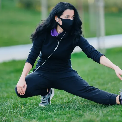 A woman stretching outdoors.