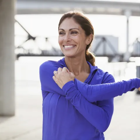A woman stretching her shoulder.
