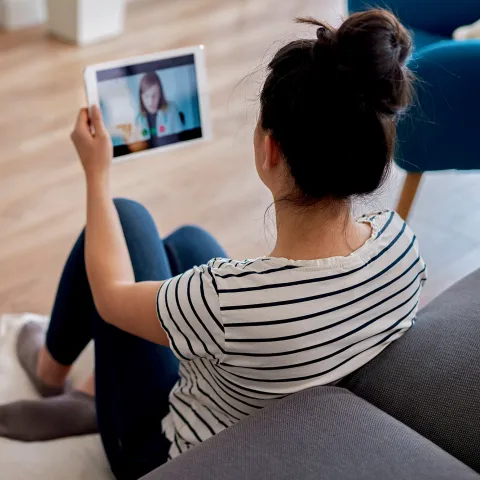 Woman on a Virtual Visit call on a tablet with a doctor while at home.