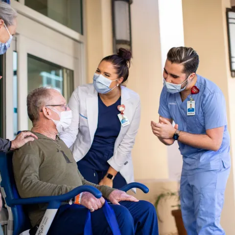 Nurses helping patient in wheel chair