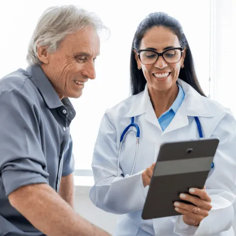 An older man speaking to a female physician.