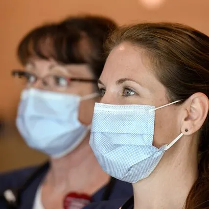 2 women wearing masks