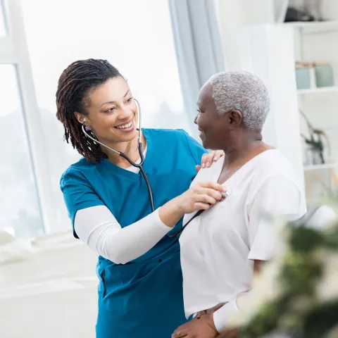 nurse-checking-her-patient-heart-while-both-smile