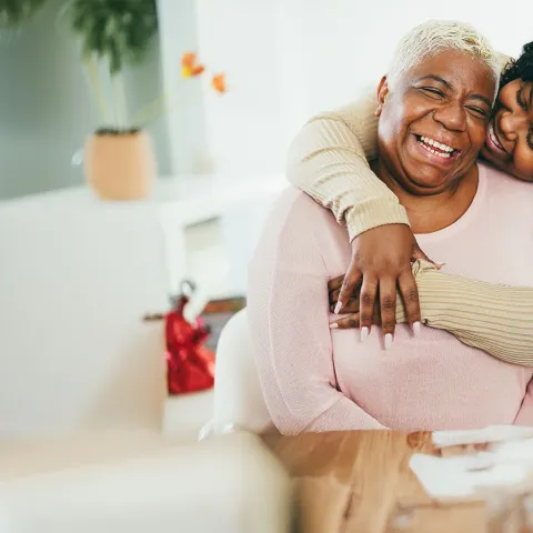 Seated mother embraced by daughter