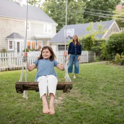 A mom playing with her daughter in the playground.
