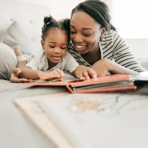 A mother reading to her daughter. 