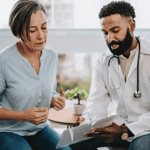 A middle-aged woman speaks to her doctor.