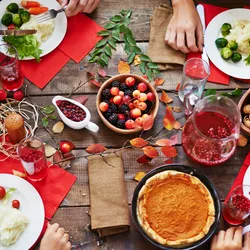 many hands reaching for food at Thanksgiving feast