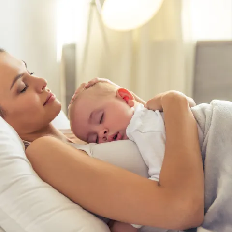 Mother sleeping with her baby