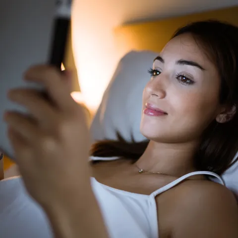 Woman in bed using her tablet