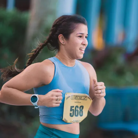 Woman wearing a number plate running in an event.