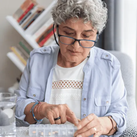 An older woman checking her medication.