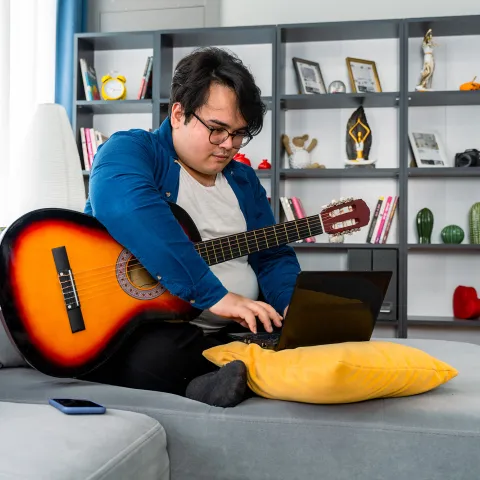A young man looking up something on his laptop
