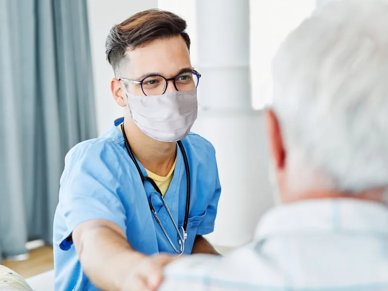 A Doctor Comforts an Elderly Patient in an Exam Room.