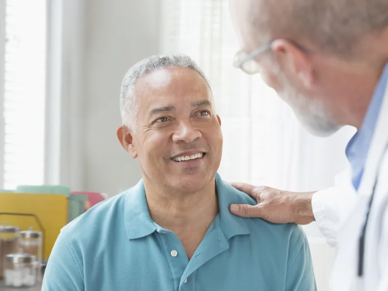 A Caucasian doctor consoles his male patient.