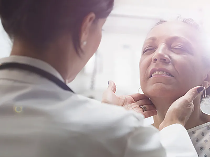 An older female patients receives care from a doctor.