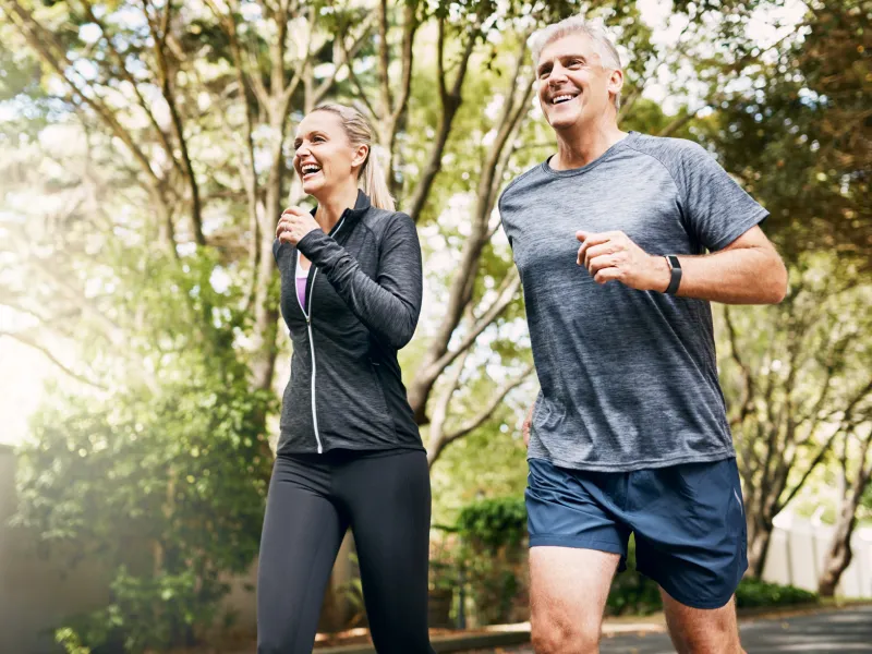 A couple runs outside together.