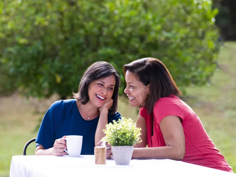 Two women sitting at a picnic table