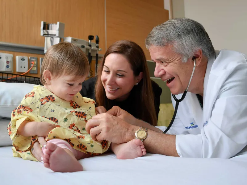 Doctor Keating using a stethoscope on his child patient