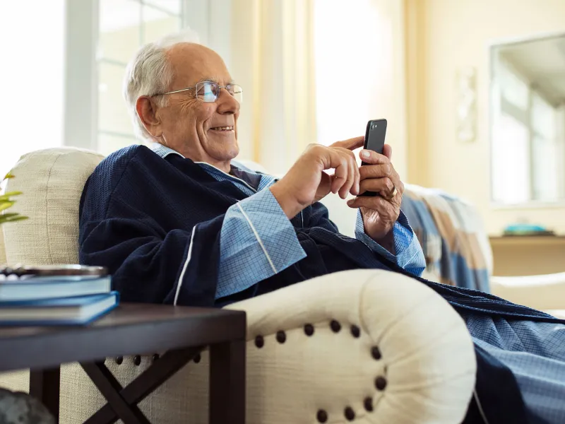 An elderly man relaxing at home seating on his couch.