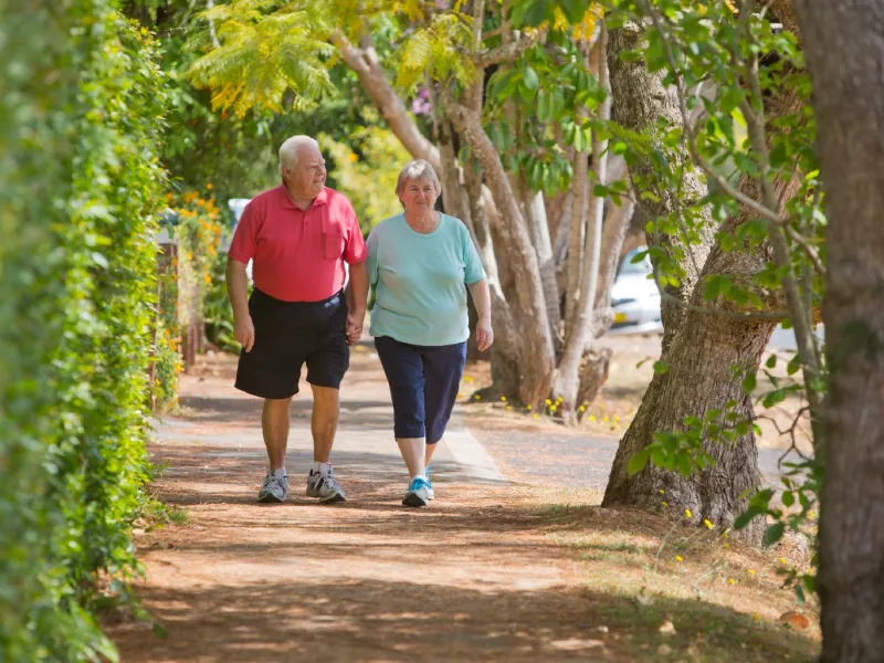 Older couple walking down a shaded street