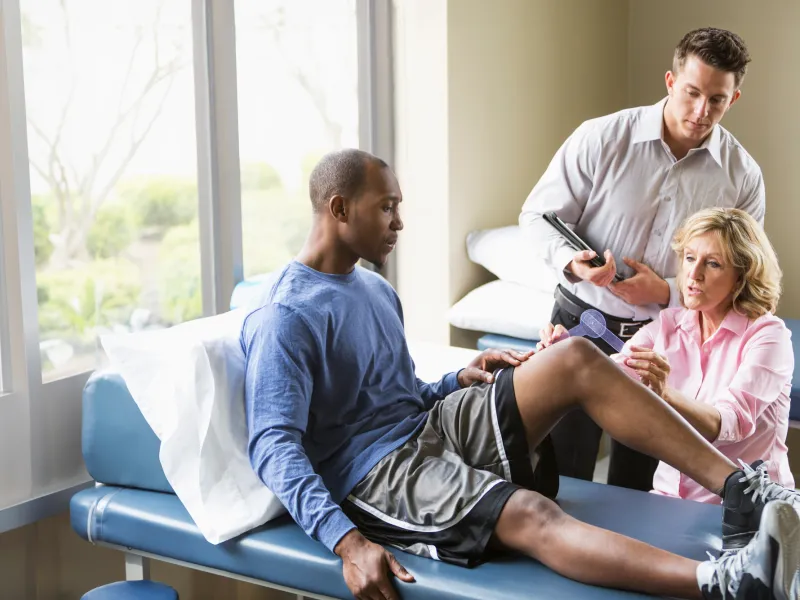 A Sports Medicine Patient is Seen by a Physician While a Resident Takes Notes