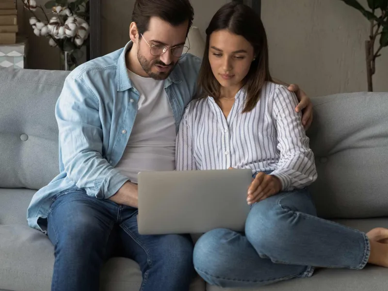 A young, married couple on their laptop