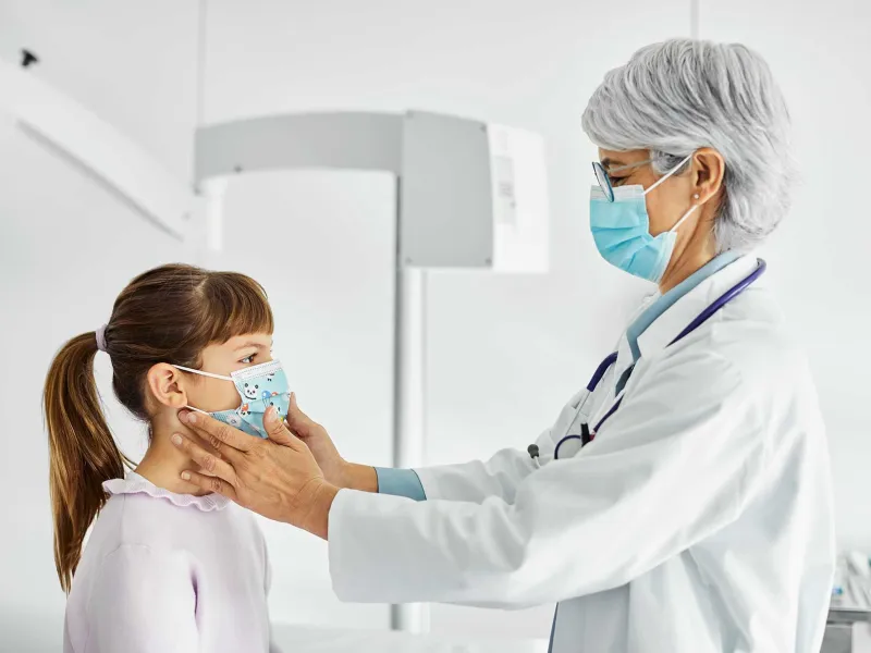 A doctor checking the neck of her pediatric patient with her fingers
