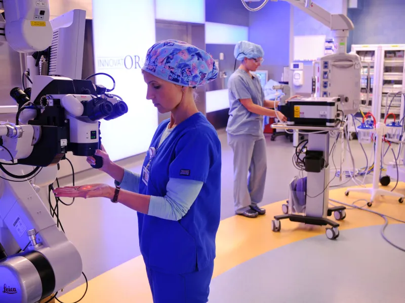 Medical specialists work with robotic surgery equipment.