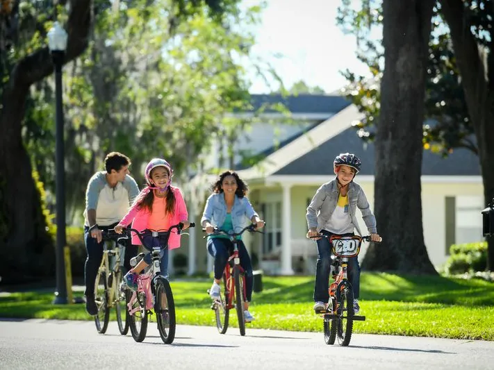 A family rides their bike in a neighborhood