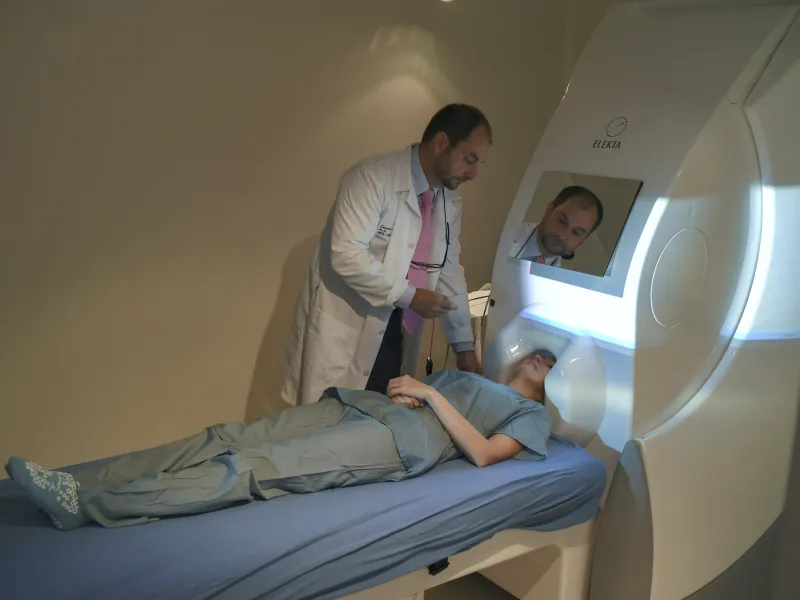 A patient undergoing a MEG scan while a physician oversees the procedure.
