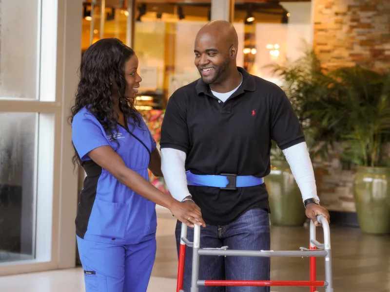 Nurse helping patient during therapy session. 