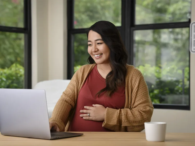 Happy pregnant woman using a computer