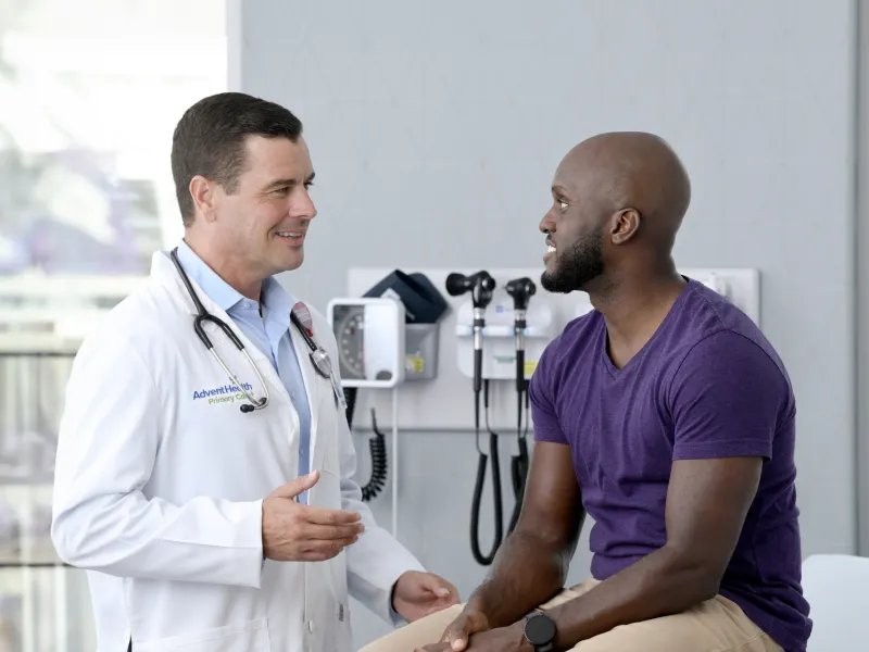 A Physician Speaks to His Male Patient in an Exam Room