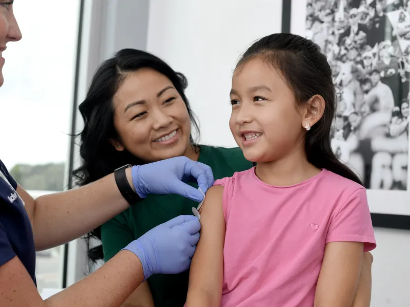 A Nurse Puts a Band Aid on a Child Patient after an Injection