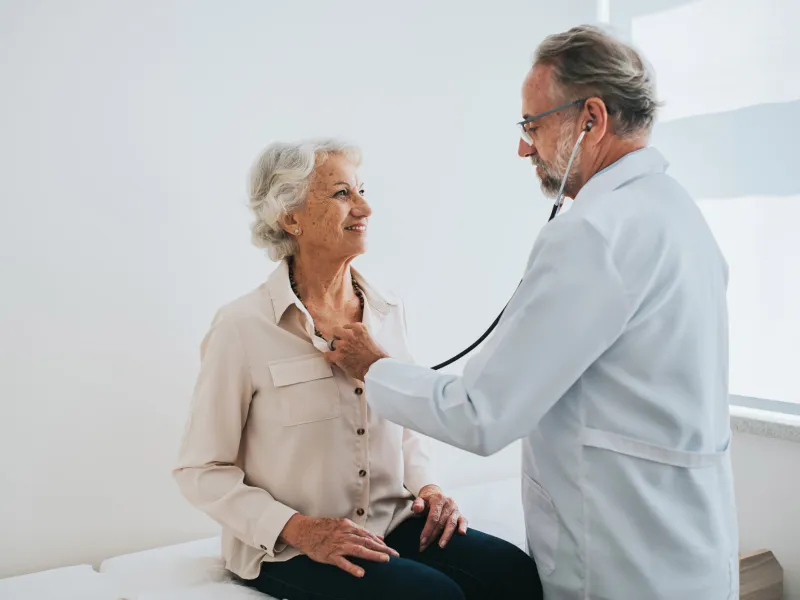 Older woman getting her heartbeat checked by a doctor.