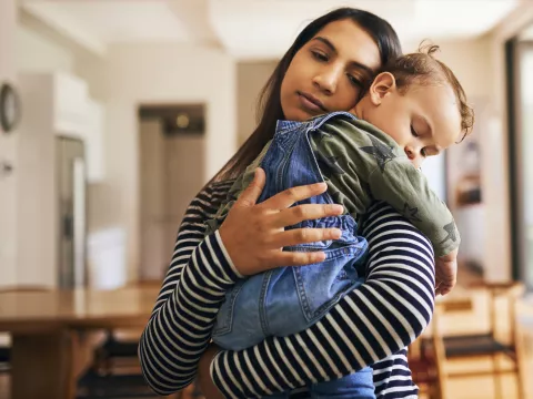 Mother holding young sleeping child