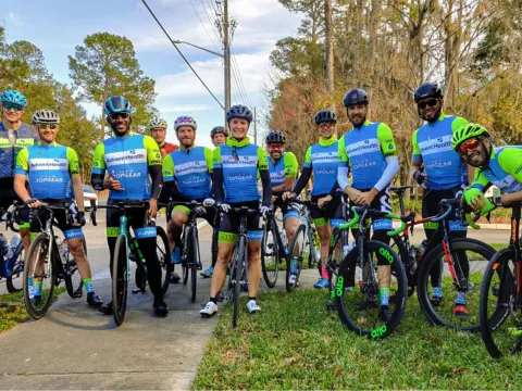 A group of cyclists standing in front of the camera