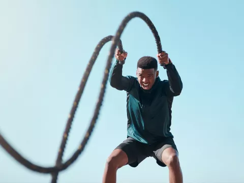 A Man Works Out Battling Ropes Outside