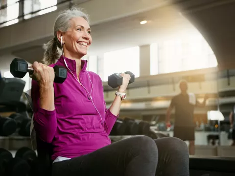 A Senior Woman Works Out at the Gym with a Smile on Her Face
