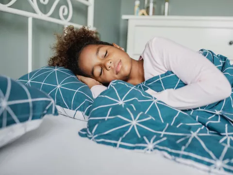 A Young Girl Sleeps Soundly in Her Bed