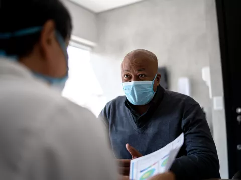 A Man Speaks to His Doctor in a Patient Room.