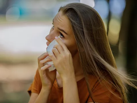 A Women Cleaning Her Eye with a Tissue.