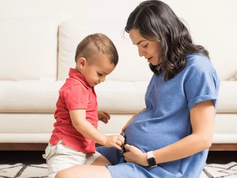 A Mother and Child Look at Mom's Pregnant Belly