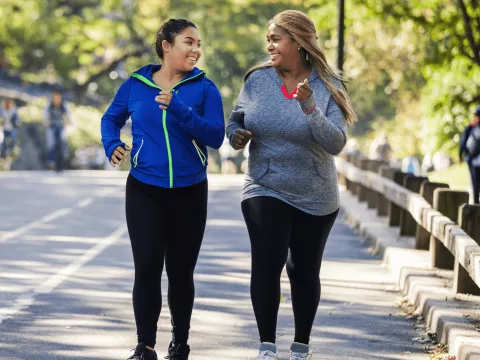 Two woman walking down the sidewalk
