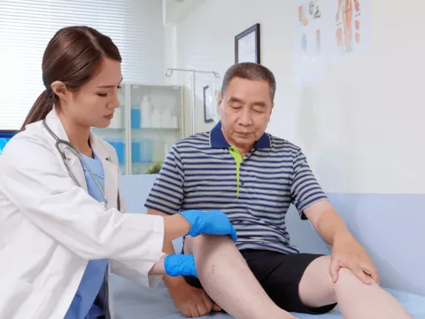 Doctor checking patient's leg