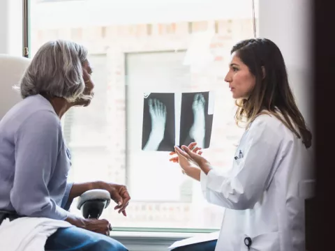 A Physician Goes Over a Patient's Foot X-rays with Her.