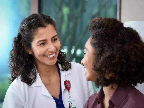 Female doctor smiling at female patient.