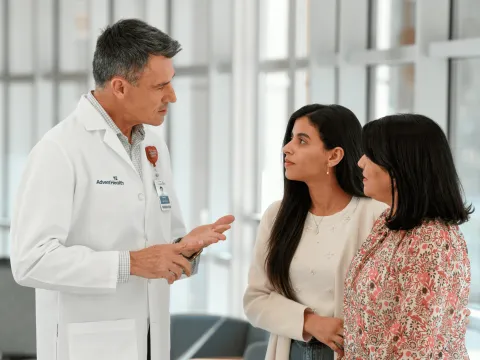 A Doctor Speaks to an Adult Patient and Her Mother in the Lobby of a Hospital