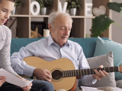 A grandfather playing guitar.